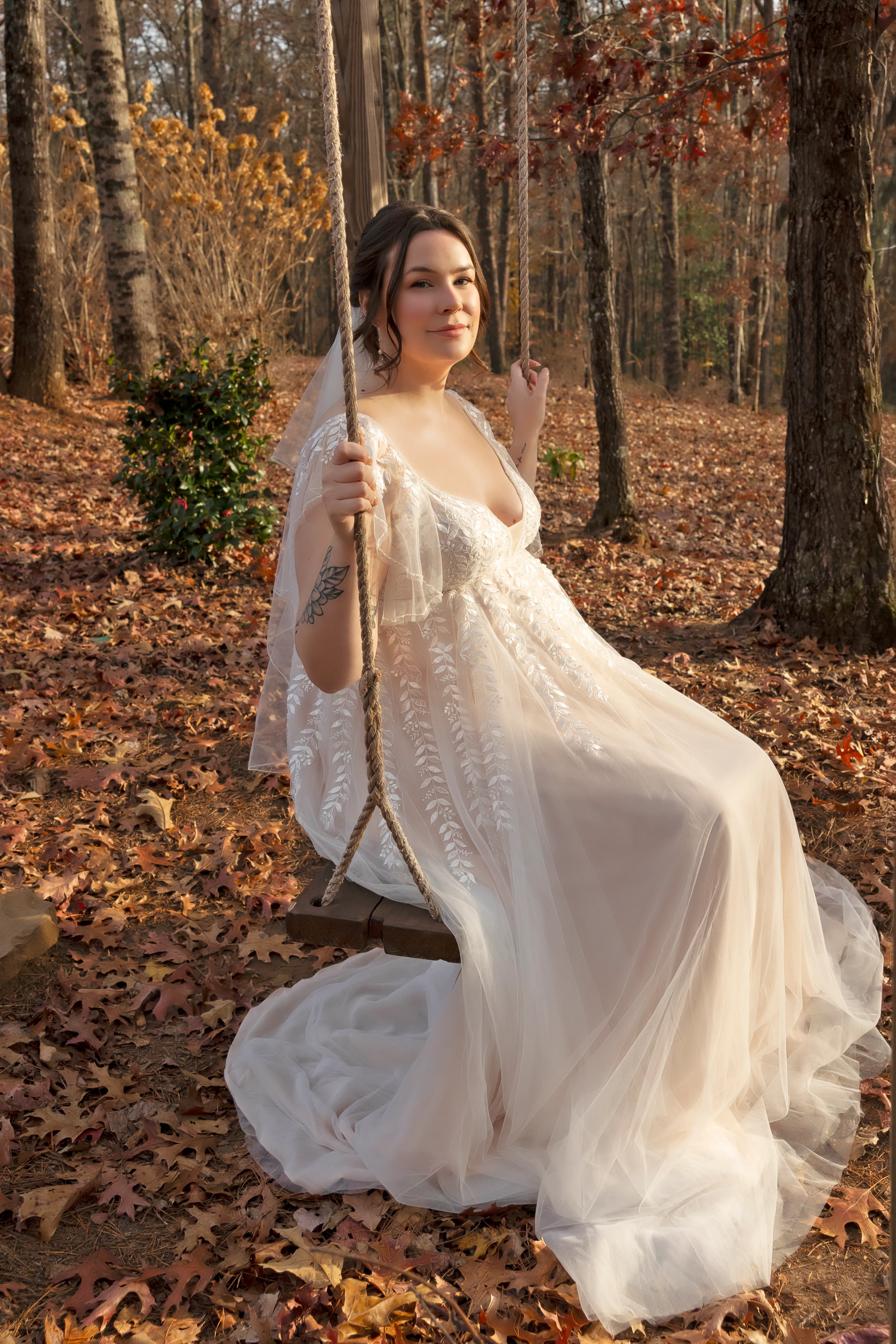 Bride sitting on a wooden swing in an autumn forest