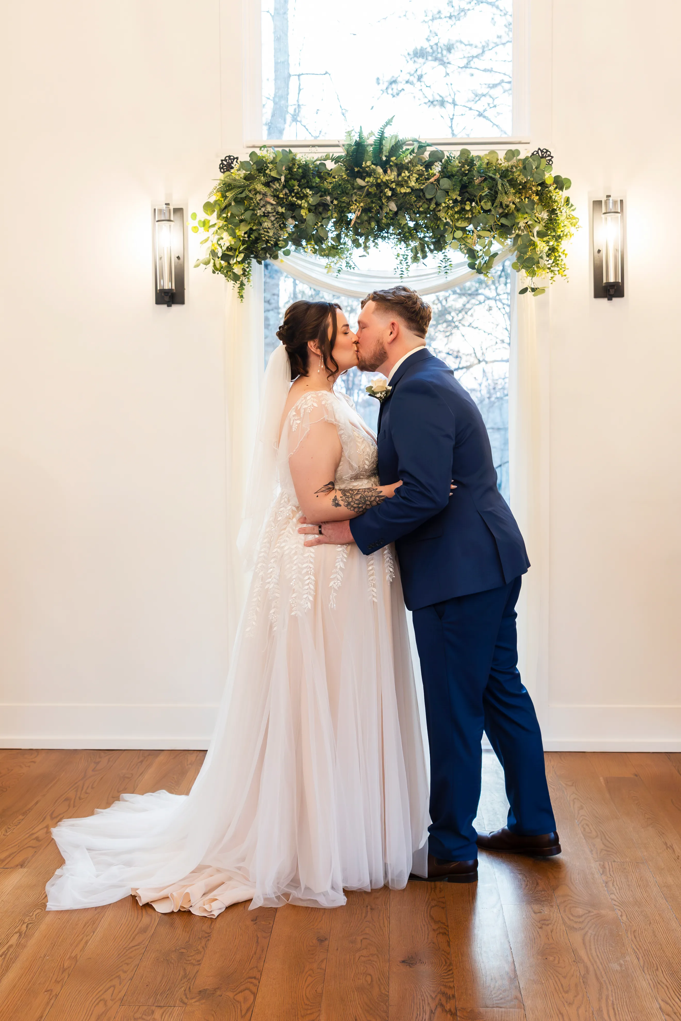 Bride and groom first kiss at the altar of Juliette Chapel under the floral arch